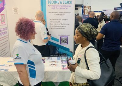 An SA Business Coaches coach in conversation with a visitor at Stand C31